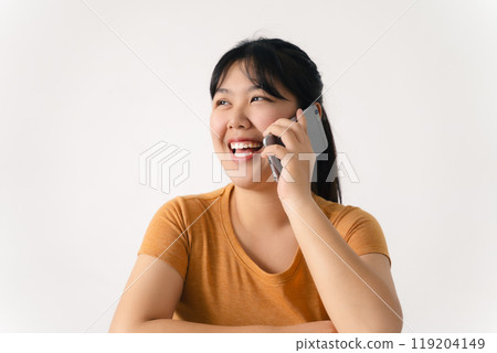 A woman is smiling while talking on her cell phone 119204149