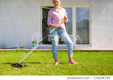 Woman using rake to clean up garden Woman using rake to clean up garden 119206789