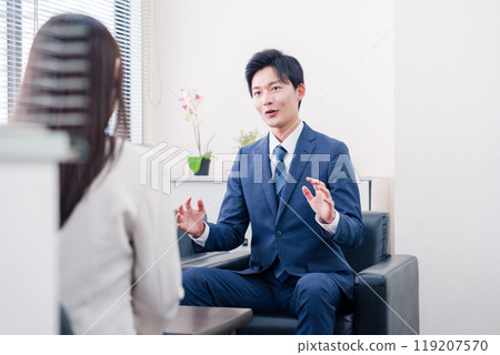 A smiling salesman negotiating with a client 119207570