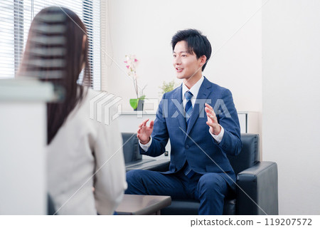 A smiling salesman negotiating with a client 119207572