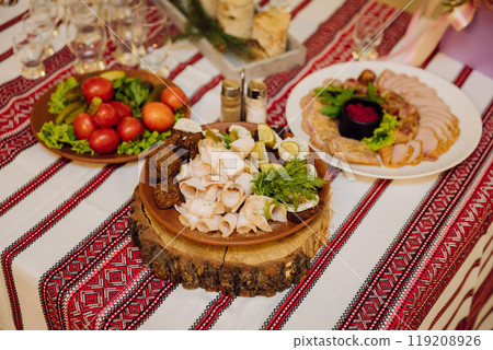 Traditional Ukrainian cuisine with lard, bread, vegetables, and meat on embroidered tablecloth 119208926