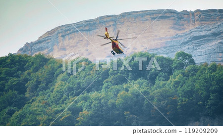 French Securite Civile or a civil defense agency helicopter on a rescue mission in the Alps, France French Securite Civile or a civil defense agency helicopter on a rescue mission in the Alps, France 119209209