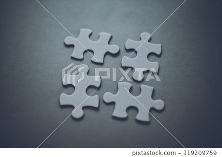 Four puzzle pieces and a gray background 119209759