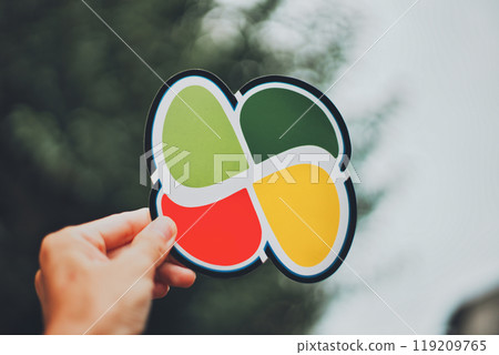 Hand of a person holding an elderly person mark and a blurred green background 119209765