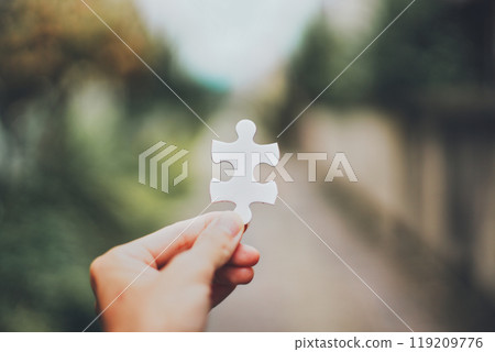 Hands of a person holding puzzle pieces Hands of a person holding puzzle pieces 119209776