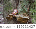 Monkey doll sitting on a mushroom 119211427