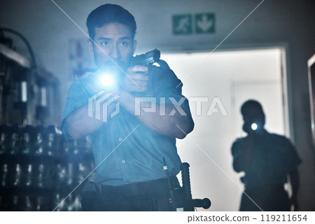 Flashlight, police and man with gun for investigation, inspection and property search at night. Surveillance team, law and security male person in dark room for safety, crime and protection service 119211654