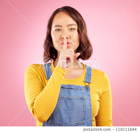 Asian person, face or finger on lips for secret, news and privacy on isolated pink background in studio. Woman portrait, hand gesture or shush emoji in quiet, whisper or noise control on mockup space 119211694