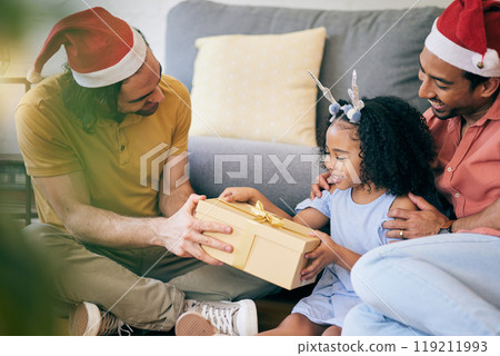 Gay, Christmas and a father with a gift for a child, celebration and holiday as a family. Smile, home and an lgbt man with a festive present for a girl kid in the living room of a house together 119211993