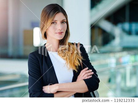 Stand tall and be bold. Cropped portrait of an attractive young businesswoman standing with her arms crossed in an office. Stand tall and be bold. Cropped portrait of an attractive young businesswoman standing with her arms crossed in an office. 119212335