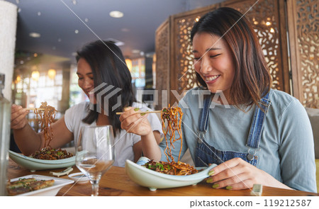 Restaurant, girl friends and smile with food, noodles and cafe happy from bonding. Asian women, eating and plate together with friendship at a table hungry with chopsticks at Japanese bar gathering 119212587