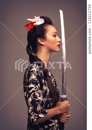 Japanese woman, fashion and sword with confidence in studio on brown background in traditional style and elegant. Asian, culture and female person with designer clothes or outfit for heritage Japanese woman, fashion and sword with confidence in studio on brown background in traditional style and elegant. Asian, culture and female person with designer clothes or outfit for heritage 119212756