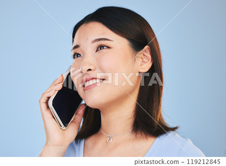 Asian woman, thinking and phone call in studio with chat, networking and smile by blue background. Young Japanese student, girl and smartphone for contact, mobile connection and memory with ideas 119212845
