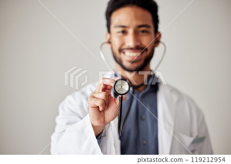 Healthcare, portrait and man doctor hand holding stethoscope in studio for hospital, checkup or exam. Face, smile and male cardiovascular expert with medical tool for chest, lungs and heartbeat check 119212954