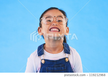 Glasses, student smile and Asian child in portrait in studio isolated on a blue background mockup space. Happy, nerd and face of school kid, girl or geek in casual clothes, fashion and style in Japan Glasses, student smile and Asian child in portrait in studio isolated on a blue background mockup space. Happy, nerd and face of school kid, girl or geek in casual clothes, fashion and style in Japan 119212968