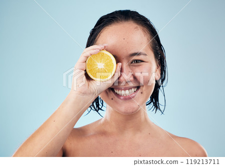 Portrait, mockup or happy woman with orange for skincare or beauty in studio on blue background. Smile, dermatology shine or Asian person with natural fruits, vitamin c or face glow for wellness 119213711