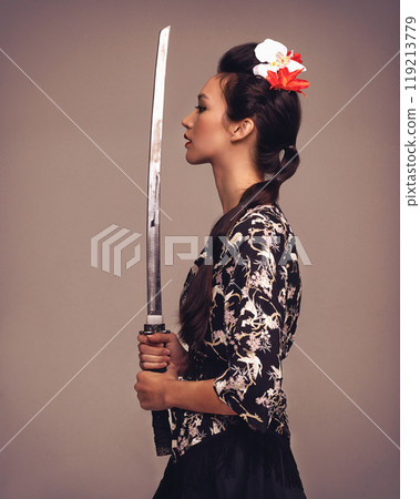 Asian woman, fashion and confident with sword in studio on brown background in traditional style and elegant. Japanese, female person and cultural with designer clothes or outfit for heritage Asian woman, fashion and confident with sword in studio on brown background in traditional style and elegant. Japanese, female person and cultural with designer clothes or outfit for heritage 119213779