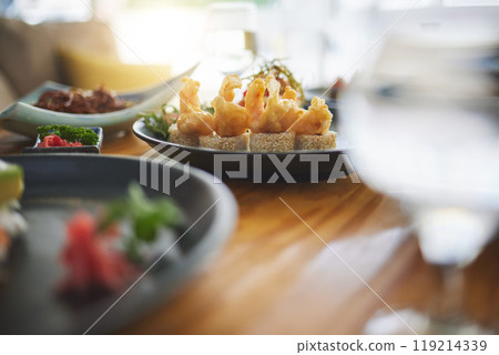 Sushi restaurant, catering and table in closeup for service, lunch or dinner with wine, glass and fish plate. Japanese cuisine, menu and seafood in diner, cafe or luxury for health, nutrition or diet Sushi restaurant, catering and table in closeup for service, lunch or dinner with wine, glass and fish plate. Japanese cuisine, menu and seafood in diner, cafe or luxury for health, nutrition or diet 119214339