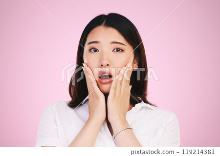 Surprise, wow and hands on woman face in studio with anxiety for fake news, drama or secret on pink background. Omg, portrait and Japanese female model shocked by gossip, announcement or emoji info 119214381