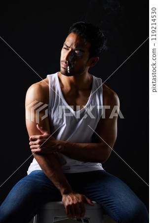 Smoking, thinking and sexy man on chair in studio in fitness, beauty aesthetic and sensual fashion. Erotic art, sexual body and male model with muscle, cigarette and black background in dark lighting Smoking, thinking and sexy man on chair in studio in fitness, beauty aesthetic and sensual fashion. Erotic art, sexual body and male model with muscle, cigarette and black background in dark lighting 119214530