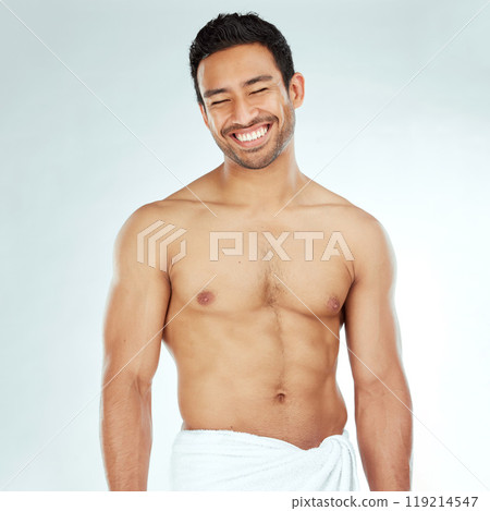 Body, cleaning and happy asian man in a towel in studio for beauty, hygiene and care on grey background. Face, smile and muscular Japanese male model with glowing skin grooming results after shower 119214547