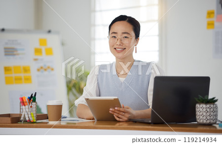 Portrait of Asian woman in office with smile, tablet and research for business website, online report or social media. Internet, digital app and businesswoman at desk with web schedule and confidence Portrait of Asian woman in office with smile, tablet and research for business website, online report or social media. Internet, digital app and businesswoman at desk with web schedule and confidence 119214934