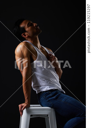 Sexy, muscle and man on chair on black background with fitness inspiration, beauty aesthetic and sensual fashion. Erotic art, sexual body and male model sitting in studio, thinking in dark lighting. 119215297