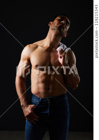 Sexy, muscle and man on black background with fitness inspiration, strong aesthetic and sensual fashion. Art, body and motivation, male model in studio thinking in dark lighting with jeans and abs. Sexy, muscle and man on black background with fitness inspiration, strong aesthetic and sensual fashion. Art, body and motivation, male model in studio thinking in dark lighting with jeans and abs. 119215343