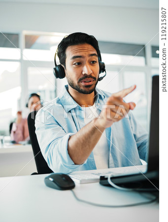 Asian man, call center and pointing in customer service, support or telemarketing at office. Businessman, consultant or agent with headphones in contact us for online advice or help at workplace 119215807