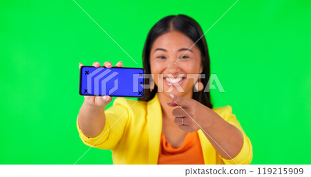 Woman, green screen and hand pointing to mobile mockup space with tracking markers on studio background. Portrait, phone and asian lady showing product placement for news and how to steps for app 119215909