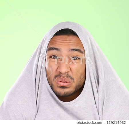 Man, portrait and silly face with disgust for funny smell, self esteem or ego on a green studio background. Shy male person or joker with goofy expression, attitude or childish behavior in discomfort 119215982