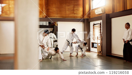 Aikido dojo, students and fight for martial arts, strike or together for combat at training, gym or class. Japanese people, group and sport for exercise, workout or fitness with zen, conflict or club 119216038
