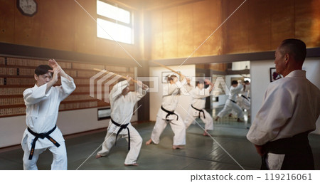 Aikido, group and class with sensei, weapon training and wooden sword for self defence exercise. Dojo, student or athlete in Japanese studio gym with fight challenge, black belt practice and fitness 119216061