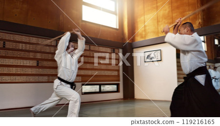 Aikido man with sensei, wooden sword and fight training in fitness, battle or action in traditional gym in Japan. Exercise, practice and student with master, black belt and Japanese martial arts dojo Aikido man with sensei, wooden sword and fight training in fitness, battle or action in traditional gym in Japan. Exercise, practice and student with master, black belt and Japanese martial arts dojo 119216165
