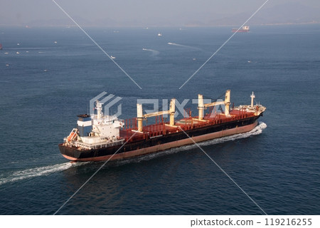 A large cargo ship passing through the Kurushima Kaikyo Bridge and heading towards Sainan A large cargo ship passing through the Kurushima Kaikyo Bridge and heading towards Sainan 119216255