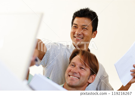 Documents, laptop or happy business people with teamwork, online solution or portfolio in project. Diversity, low angle or men planning in office talking, conversation or speaking of paperwork info 119216267