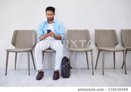 Waiting room, phone and man in an office for interview in job search for appointment. Hiring, career and Indian male person sitting for recruitment meeting with human resources in modern workplace. 119216499