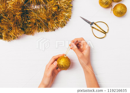 A person is decorating a gold ornament with glitter A person is decorating a gold ornament with glitter 119216635