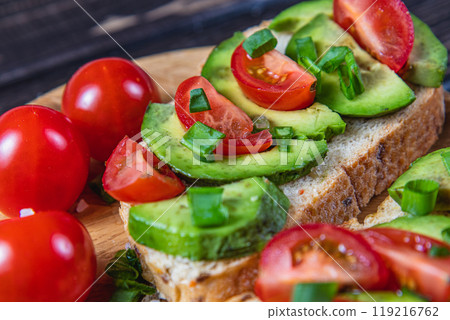Avocado toast topped with tomato and green onion on a slice of carrot bread Avocado toast topped with tomato and green onion on a slice of carrot bread 119216762