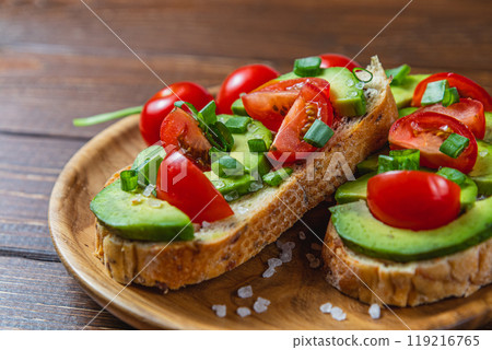 Avocado toast topped with tomato and green onion on a slice of carrot bread Avocado toast topped with tomato and green onion on a slice of carrot bread 119216765