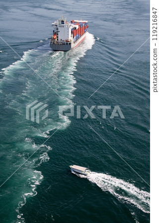 A fishing boat entering the wake of a container ship A fishing boat entering the wake of a container ship 119216847