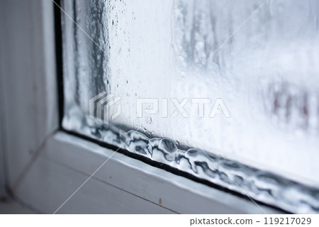 Raindrops on a window pane capture natures beauty, creating a cozy, artistic ambiance 119217029