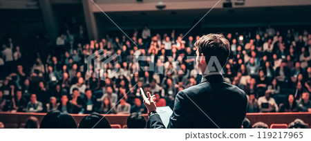 Presenter speaking to a focused audience 119217965