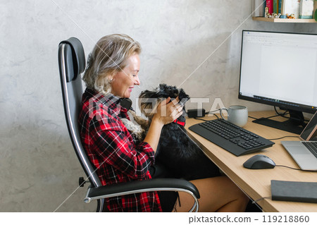 Mature Woman Working from Home with Her Small Dog 119218860