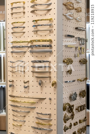 Display of assorted cabinet handles and knobs on pegboard. Interior design and hardware selection. Display of assorted cabinet handles and knobs on pegboard. Interior design and hardware selection. 119218915