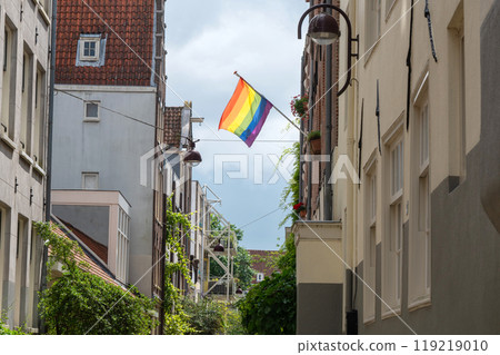 Pride flag waving on a narrow street with old buildings. Pride flag waving on a narrow street with old buildings. 119219010