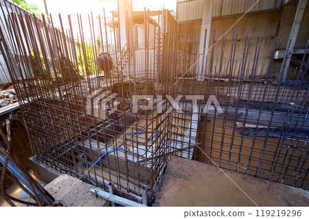A construction site displaying a reinforced concrete foundation with steel rebar 119219296
