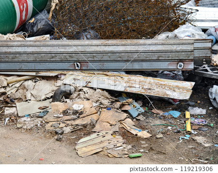 A pile of garbage with a bucket, rope, bottles, and other items at a landfill 119219306