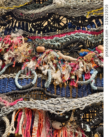 A ropes piece of art is displayed on a wooden wall 119219316