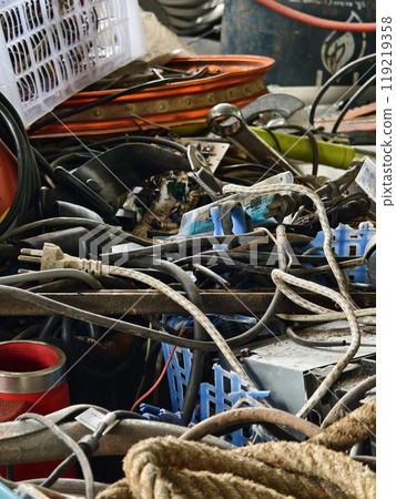 A pile of garbage with a bucket, rope, bottles, and other items at a landfill 119219358